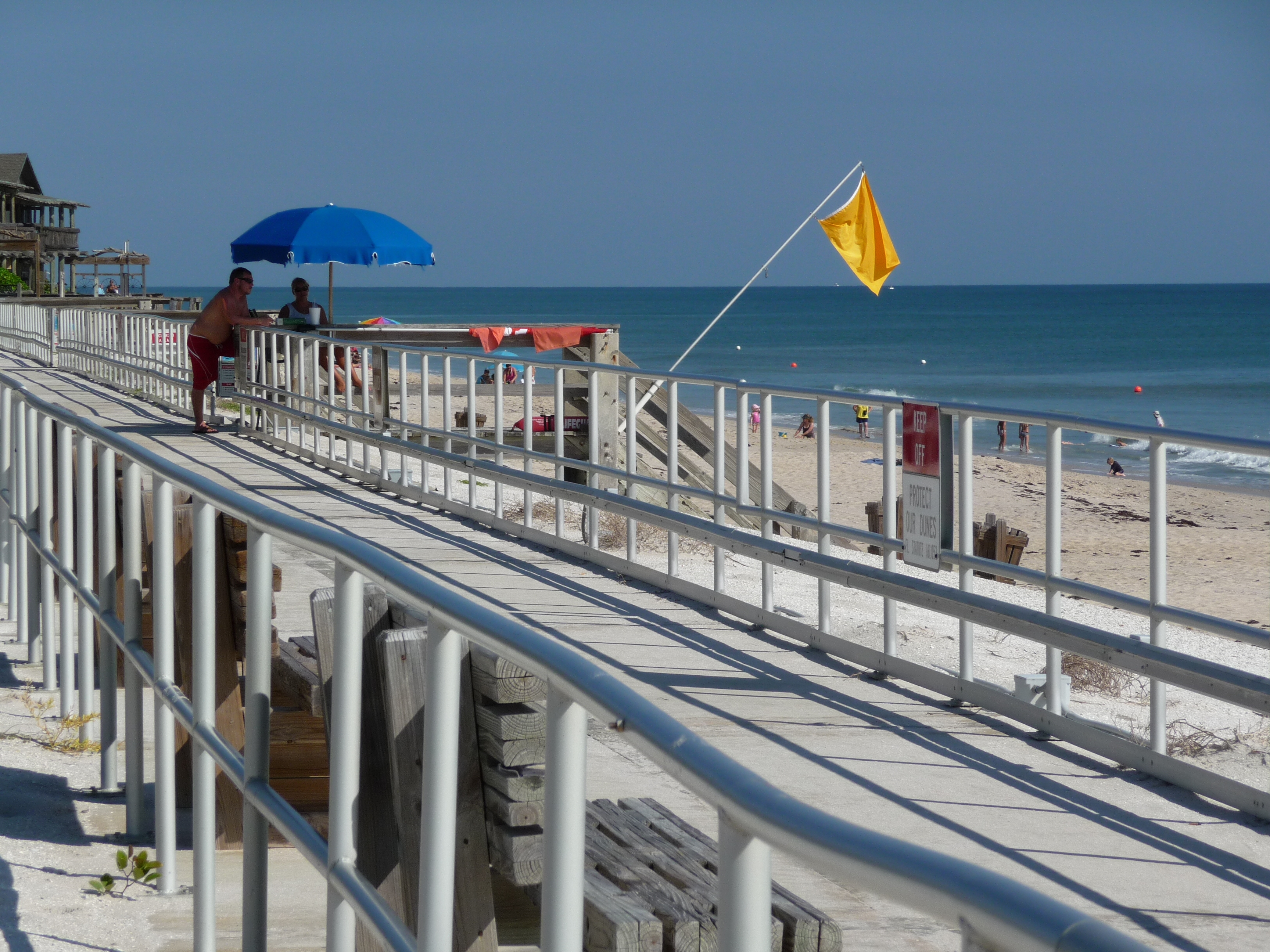 Humiston Beach in 2009, showing the former boardwalk later demolished. Archival photograph; not the current access route or current yellow flag.