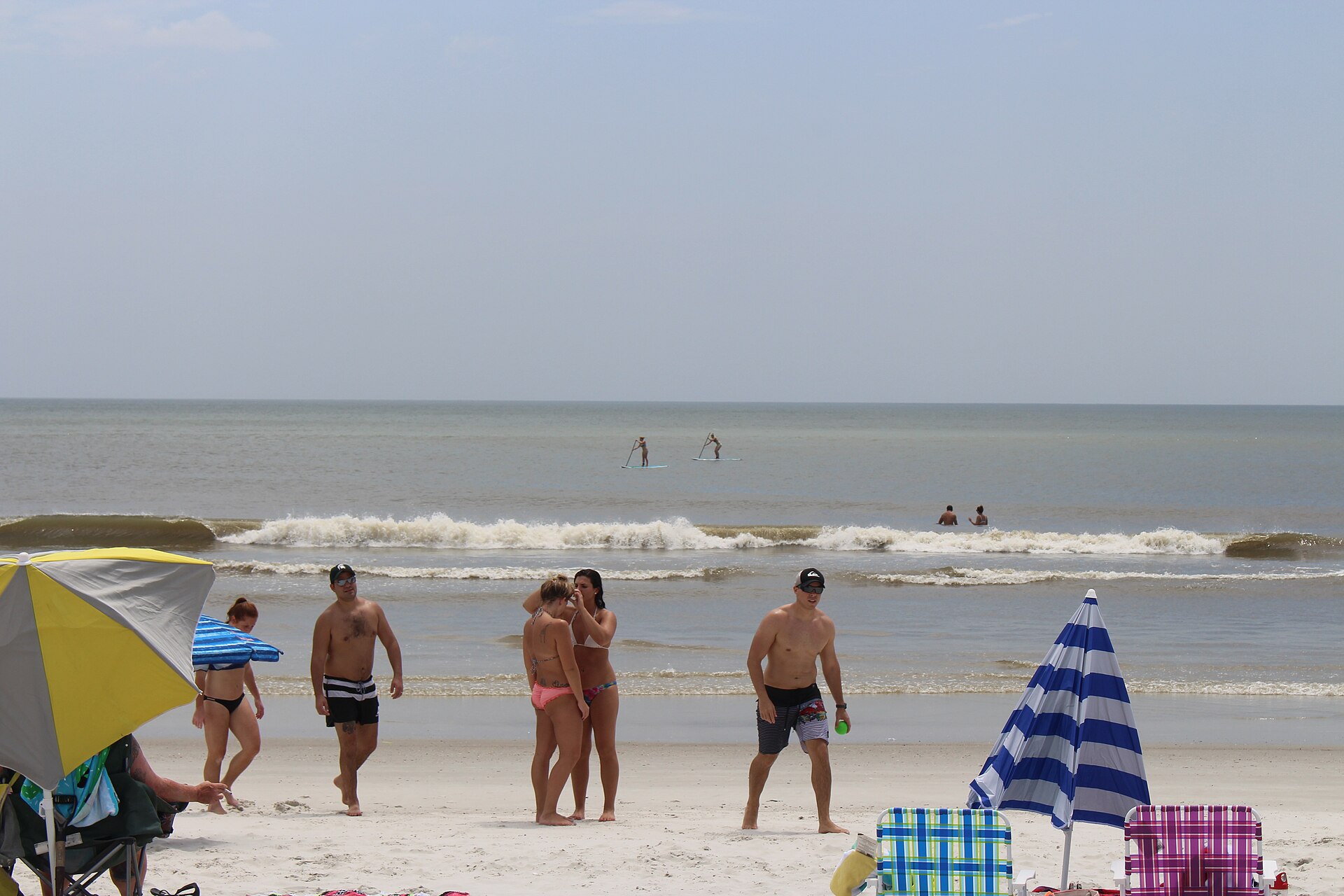 Neptune Beach · paddleboarders and shoreline